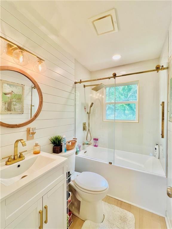2026 Norman Ln, Gulf Shores, AL 36542 - full bathroom featuring vanity, toilet, enclosed tub / shower combo, wood walls, and wood finished floors