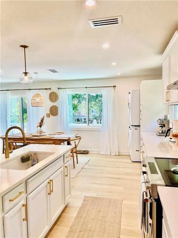 2026 Norman Ln, Gulf Shores, AL 36542 - kitchen with stacked washer and dryer, visible vents, plenty of natural light, and a sink