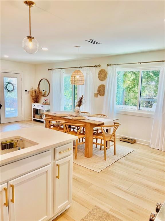 2026 Norman Ln, Gulf Shores, AL 36542 - kitchen with a healthy amount of sunlight, light wood finished floors, visible vents, and hanging light fixtures