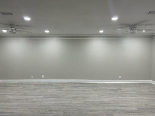 spare room with ceiling fan, ornamental molding, and light wood-type flooring