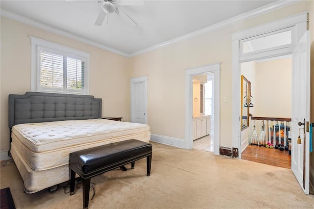 bedroom with light colored carpet, ceiling fan, crown molding, and ensuite bathroom