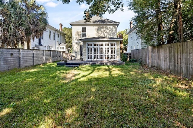 rear view of house with a yard and a wooden deck