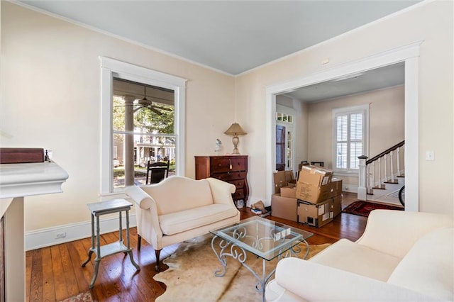 living area featuring a wealth of natural light, crown molding, ceiling fan, and hardwood / wood-style flooring