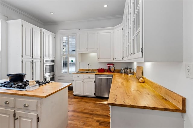 kitchen featuring white cabinetry, light wood-type flooring, butcher block counters, and appliances with stainless steel finishes