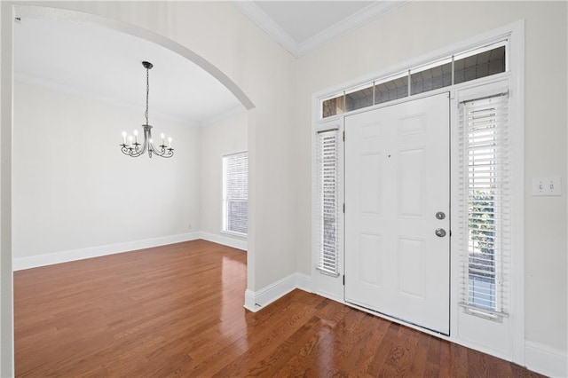 foyer with a chandelier, ornamental molding, and hardwood / wood-style flooring