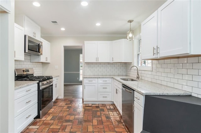 kitchen featuring pendant lighting, white cabinets, sink, decorative backsplash, and stainless steel appliances