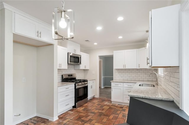 kitchen with white cabinetry, sink, hanging light fixtures, stainless steel appliances, and tasteful backsplash