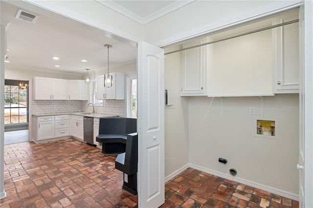 kitchen featuring ornamental molding, sink, pendant lighting, dishwasher, and white cabinetry