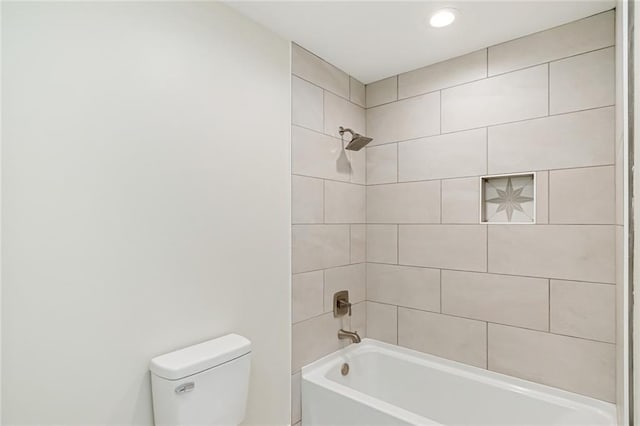 bathroom featuring toilet and tiled shower / bath