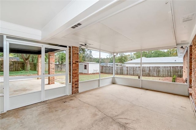 unfurnished sunroom featuring ceiling fan