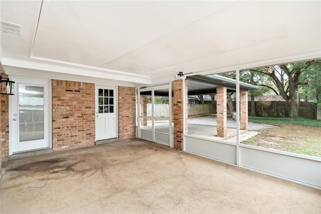 unfurnished sunroom featuring a tray ceiling and plenty of natural light