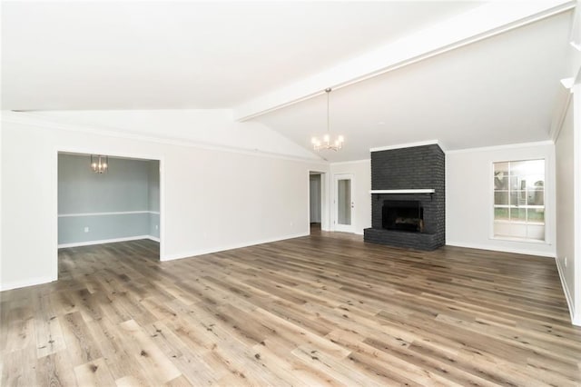 unfurnished living room featuring hardwood / wood-style floors, vaulted ceiling with beams, a notable chandelier, and a brick fireplace