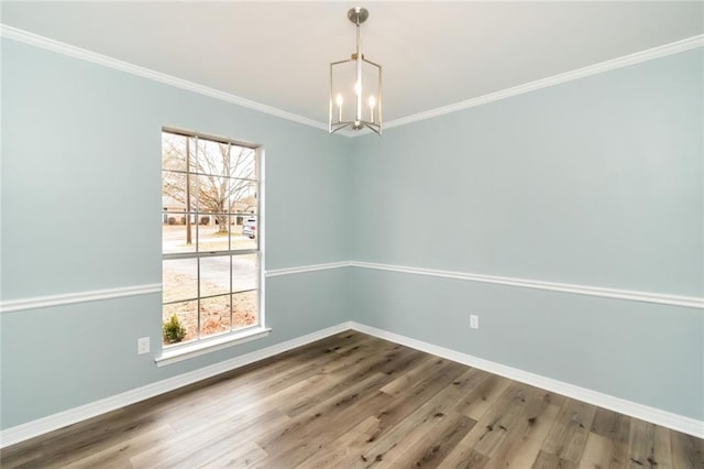 unfurnished dining area with a chandelier, ornamental molding, a healthy amount of sunlight, and wood-type flooring