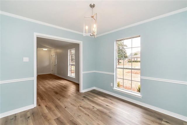 unfurnished dining area featuring hardwood / wood-style floors, a notable chandelier, and ornamental molding