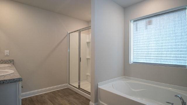 bathroom with independent shower and bath, vanity, and hardwood / wood-style flooring