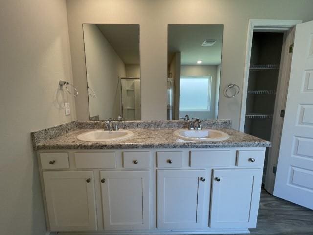 bathroom with vanity, an enclosed shower, and wood-type flooring