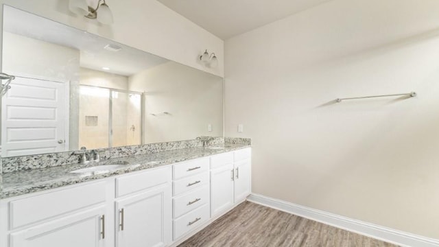 bathroom featuring hardwood / wood-style flooring, vanity, and an enclosed shower