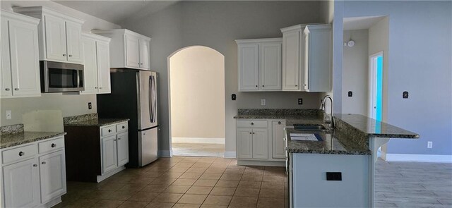 2509 Hedgerow Dr, Mobile, AL 36695 - kitchen with a sink, arched walkways, stainless steel appliances, baseboards, and a peninsula