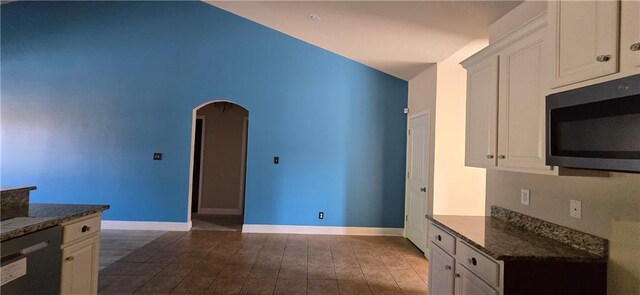 2509 Hedgerow Dr, Mobile, AL 36695 - kitchen with stainless steel microwave, arched walkways, baseboards, dark tile patterned flooring, and black dishwasher