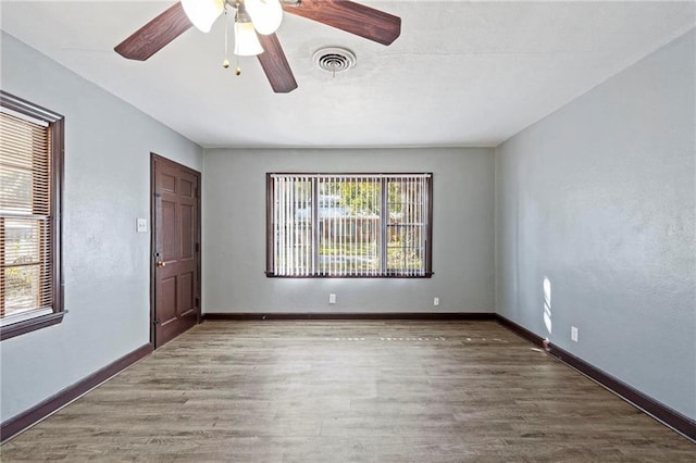 spare room with dark hardwood / wood-style flooring and ceiling fan