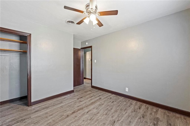 unfurnished bedroom with light hardwood / wood-style floors, a closet, and ceiling fan