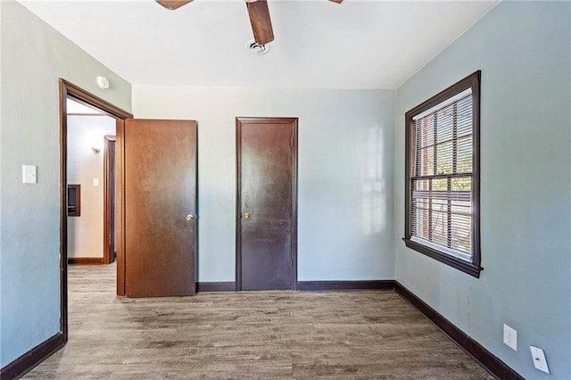 unfurnished bedroom with ceiling fan, wood-type flooring, and a closet