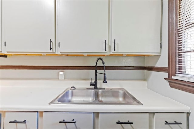 kitchen featuring white cabinetry and sink