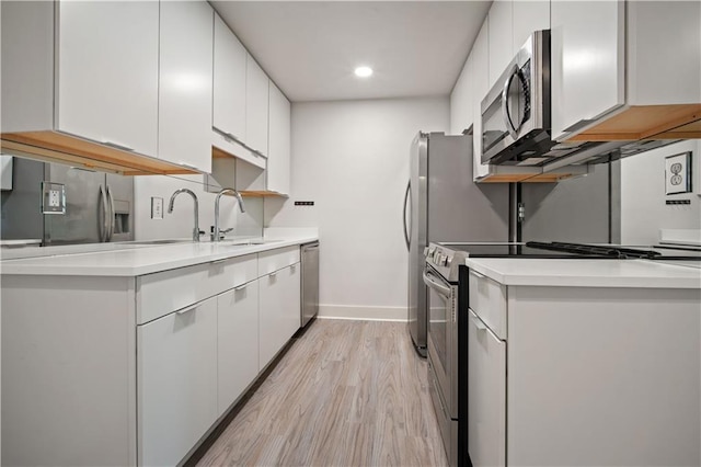 3655 Old Shell Rd Unit 121, Mobile, AL 36608 - kitchen with appliances with stainless steel finishes, white cabinetry, light wood finished floors, light countertops, and recessed lighting