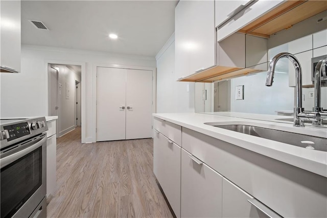 3655 Old Shell Rd Unit 121, Mobile, AL 36608 - kitchen with stainless steel electric range oven, light countertops, light wood finished floors, white cabinets, and recessed lighting