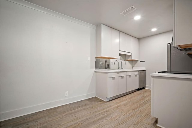 3655 Old Shell Rd Unit 121, Mobile, AL 36608 - kitchen with stainless steel appliances, light countertops, light wood-type flooring, white cabinets, and recessed lighting