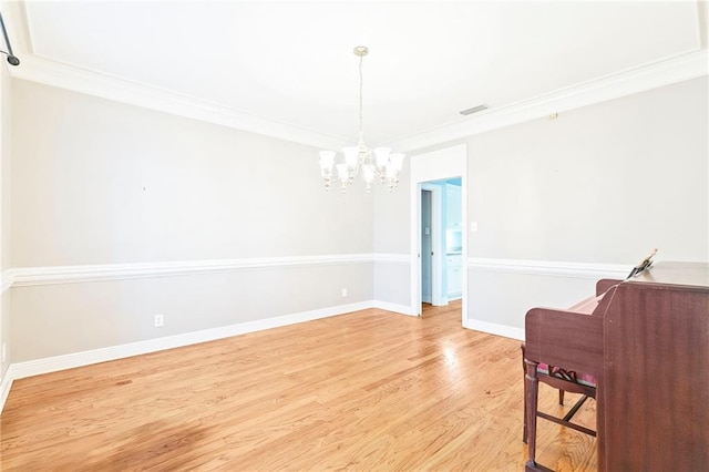 interior space with ornamental molding, light hardwood / wood-style floors, and an inviting chandelier