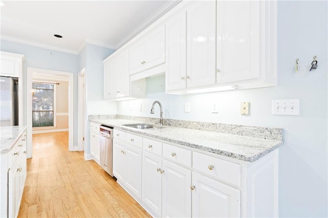 kitchen with light stone countertops, sink, light hardwood / wood-style floors, white cabinets, and appliances with stainless steel finishes