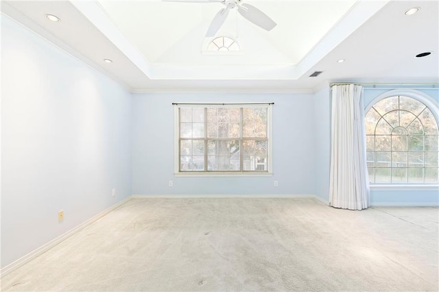 carpeted empty room featuring a tray ceiling, ceiling fan, and ornamental molding