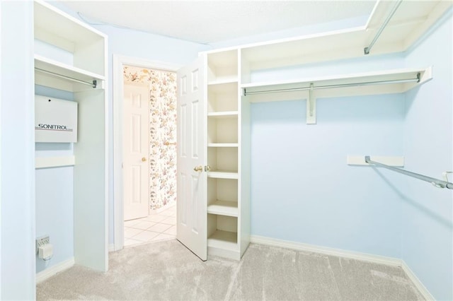 walk in closet featuring light carpet