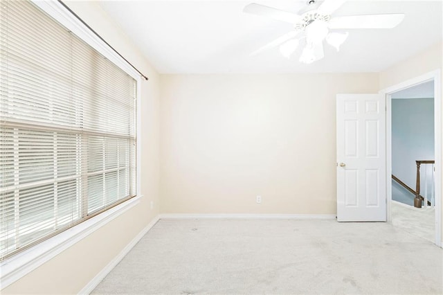 carpeted spare room with ceiling fan