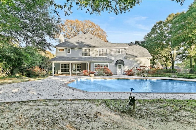 back of property featuring a fenced in pool and a patio area