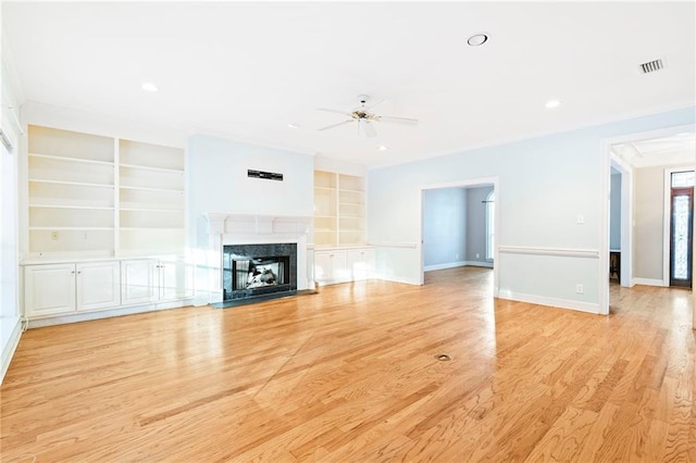 unfurnished living room featuring ceiling fan, light hardwood / wood-style floors, built in features, and a high end fireplace