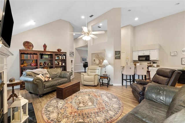 1045 Cross Gates Pl, Mobile, AL 36609 - living room with ceiling fan, a fireplace, light wood finished floors, and high vaulted ceiling