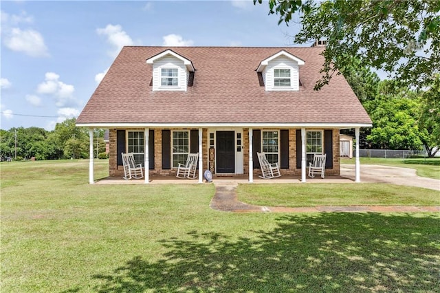 new england style home with a front yard and covered porch