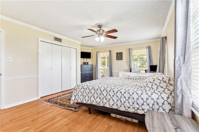 bedroom with hardwood / wood-style flooring, a closet, ornamental molding, and a textured ceiling