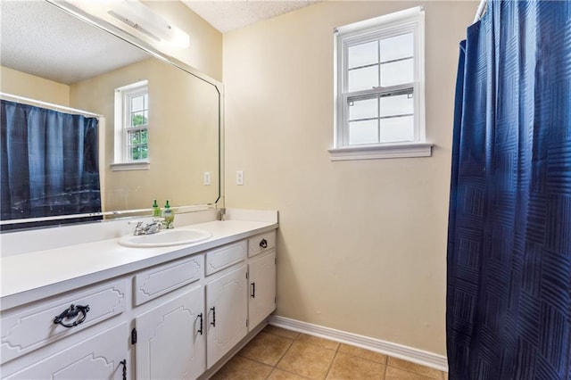 bathroom featuring tile patterned flooring, vanity, and a textured ceiling