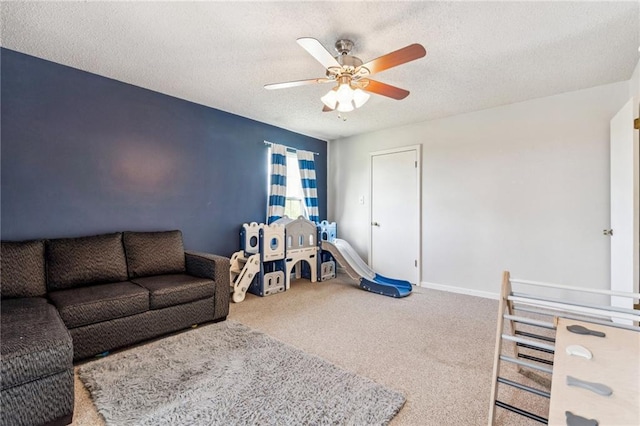 rec room with ceiling fan, carpet, and a textured ceiling