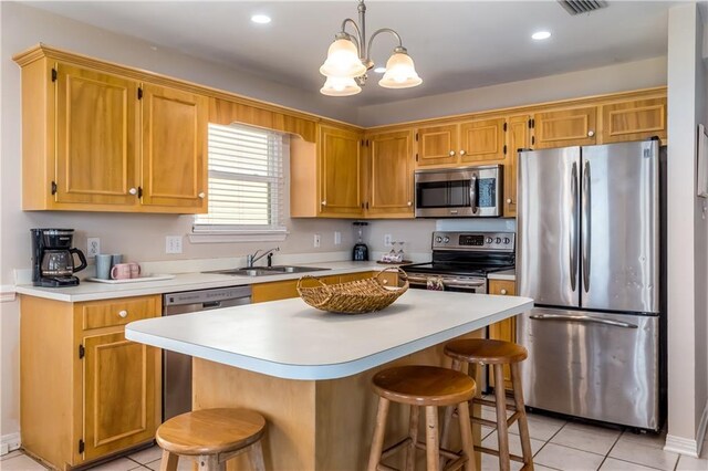 2354 Island Shores Dr, Dauphin Island, AL 36528 - kitchen with a kitchen bar, appliances with stainless steel finishes, a sink, and light tile patterned flooring