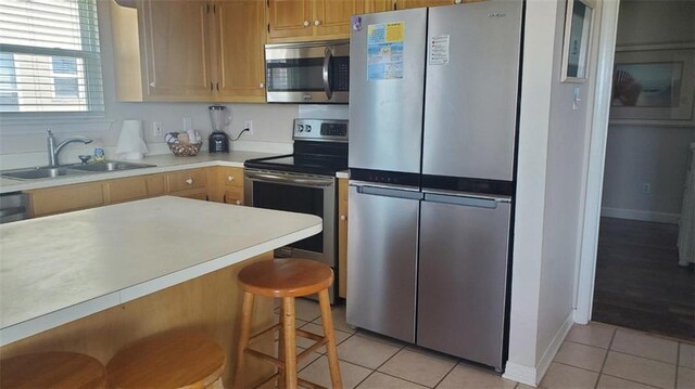 2354 Island Shores Dr, Dauphin Island, AL 36528 - kitchen with a sink, light tile patterned flooring, baseboards, light countertops, and appliances with stainless steel finishes