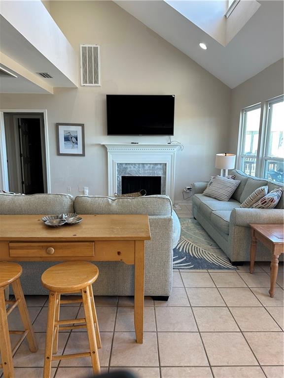 2354 Island Shores Dr, Dauphin Island, AL 36528 - living area with a tiled fireplace, visible vents, recessed lighting, high vaulted ceiling, and light tile patterned floors