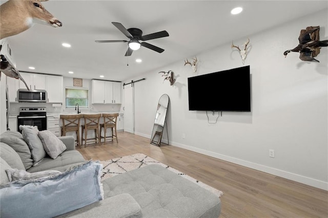 254 Fairford Rd, Calvert, AL 36513 - living area featuring light wood-style floors, a barn door, recessed lighting, and ceiling fan