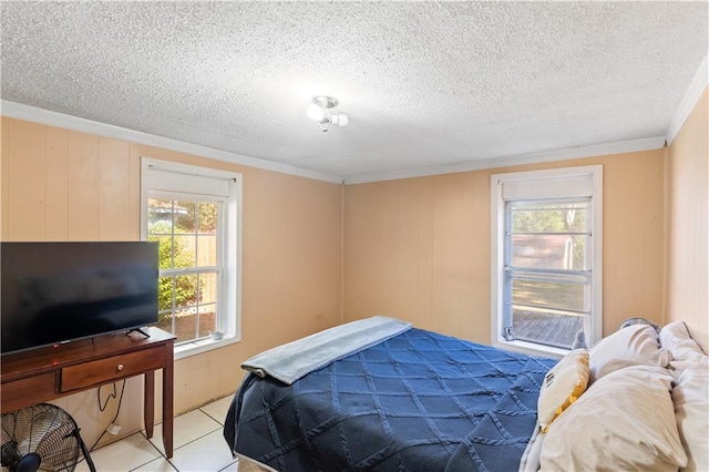 bedroom with a textured ceiling, ornamental molding, and multiple windows