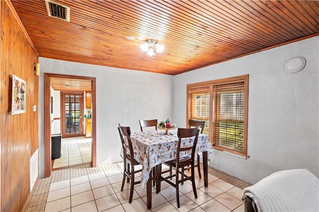 tiled dining space with wood ceiling and wooden walls