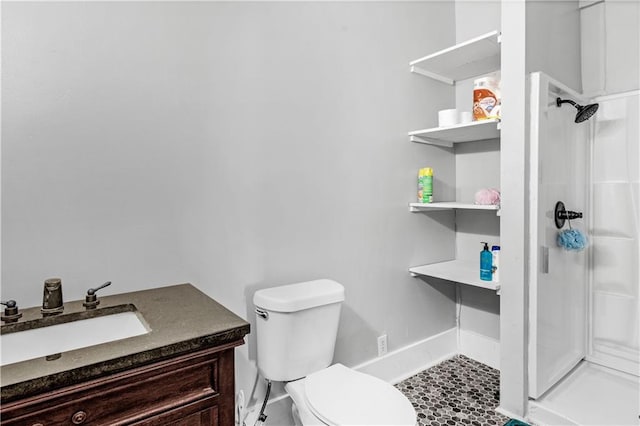 bathroom featuring vanity, toilet, and a shower