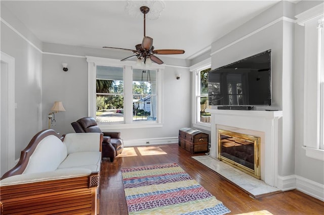 living room with ceiling fan, hardwood / wood-style floors, and a high end fireplace